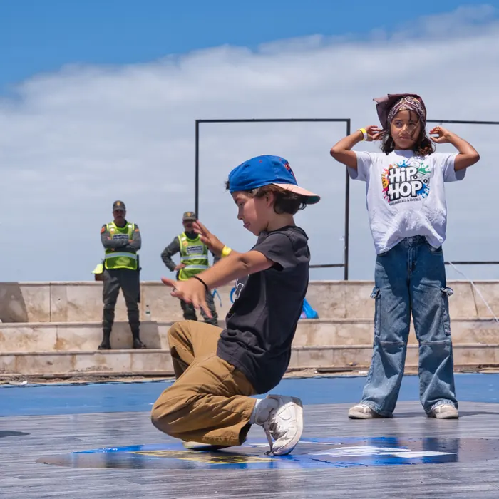 Un enfant au sol pendant l'atelier, une petite fille au t-shirt Hip Hop derrière lui