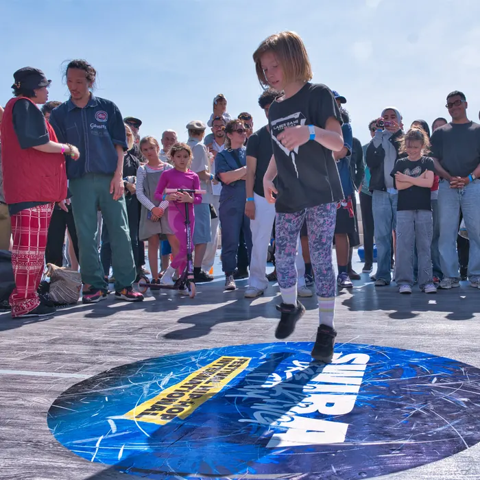 Une jeune danseuse sur le logo Swira au centre du cercle