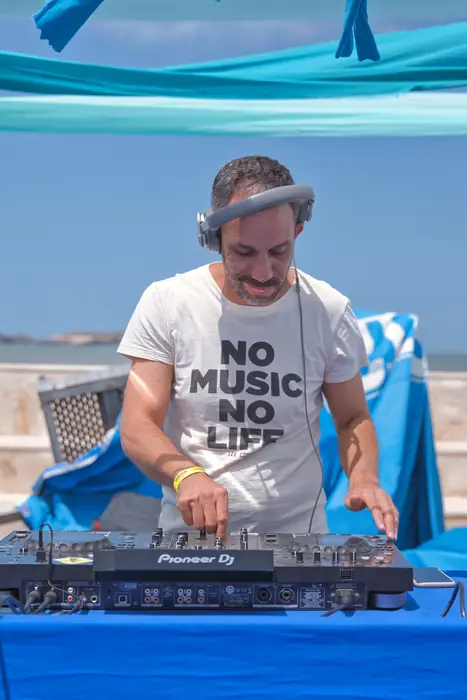 Le DJ aux platines face à l'océan