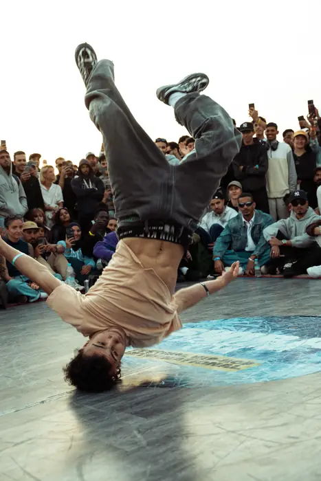 Un danseur figé sur une main, jambes en l'air