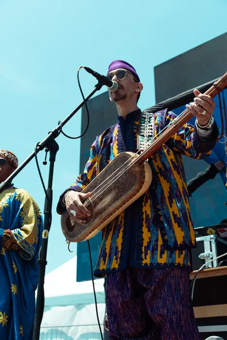 Un musicien gnaoua au guembri sur la scène du village