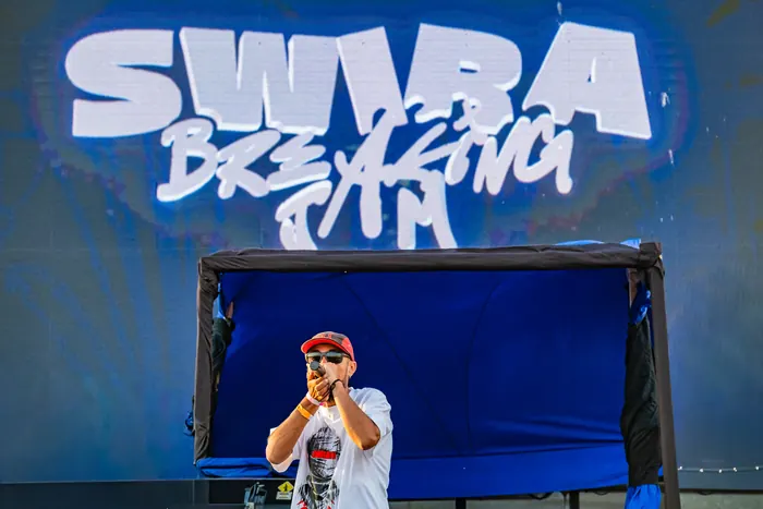 Le MC sur la scène, sous le logo Swira Breaking Jam